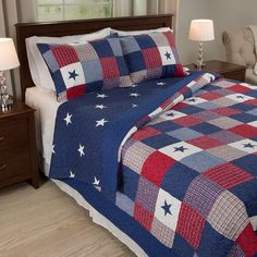 a bed with red, white and blue bedspread on top of it in a bedroom