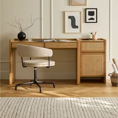 a desk with a chair and pictures on the wall above it, along with a rug