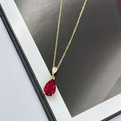 "Ruby Red Crystal Charm Necklace, Ruby Red Teardrop Pendant Necklace, Ruby Red Charm Necklace, Gold Layering Necklace, Red Teardrop Charm. This ruby red crystal teardrop pendant necklace adds the finishing touch to any outfit. Perfect for yourself, your mom, best friend, bridal party, and more! The pendant frame and chain are made from anti-tarnish gold materials. Measurements: Necklace length is 15.5\" plus 2 inches extender chain for adjustment. Teardrop crystal is 13 mm x 9 mm Necklace made i Red Teardrop Necklace, Necklace Board, Red Crystal Necklace, Teardrop Jewelry, Red Charm, Necklace Ruby, Green Charms, Gold Jewellry, Emerald Green Earrings