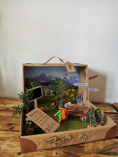 an open cardboard box filled with lots of small things on top of a wooden table