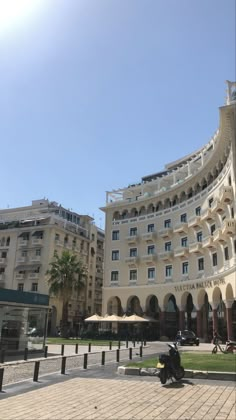 the building has many windows and balconies on it's sides, along with umbrellas