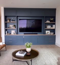 a living room filled with furniture and a flat screen tv mounted on a wall above a coffee table