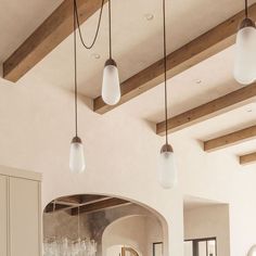 a living room filled with furniture and lots of lights hanging from the ceiling above it