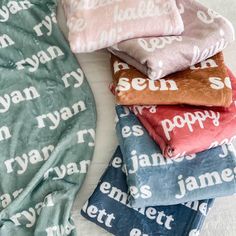 four blankets stacked on top of each other with the names of different people printed on them