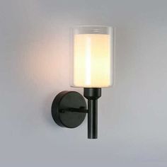 a black wall light with a white glass shade on the top and bottom half of it