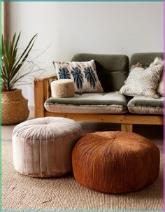 a living room filled with furniture and pillows on top of carpeted floor next to potted plants