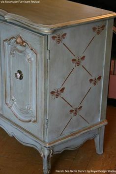 an old blue cabinet with gold trimmings on the doors and drawers is sitting in a living room