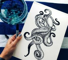 a person is drawing an octopus on paper