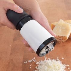 a person is grating cheese on a cutting board with a slice of bread in the background