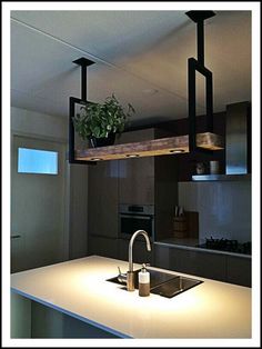 a kitchen with a sink, stove and counter top in the middle is lit up by lights