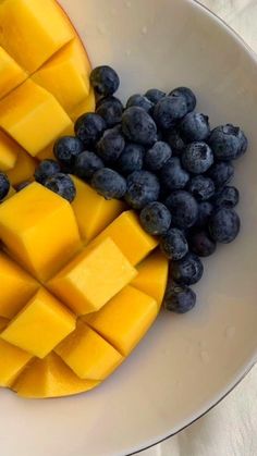 blueberries and mango slices in a white bowl