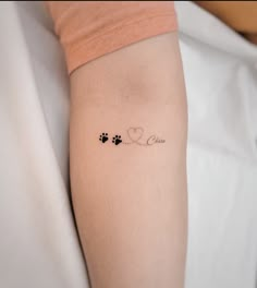 a person with a tattoo on their arm that says love and two dogs paw prints