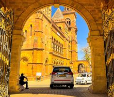 a car is parked in front of an archway