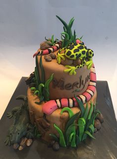 there is a cake decorated with animals and plants