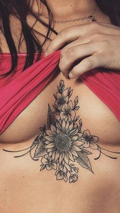 a woman with a tattoo on her chest is looking down at the bottom of her stomach