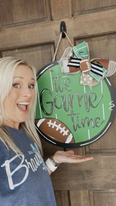 a woman is standing in front of a door with a sign that says it's game time