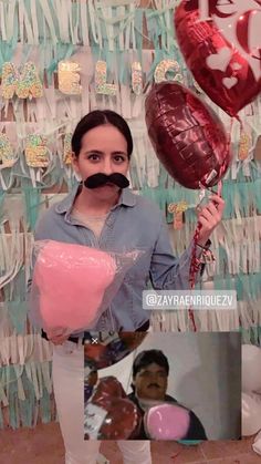 a woman holding balloons and a moustache in front of a wall with hearts