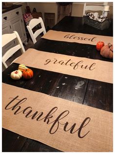 the table is set with two place mats that say thank and have pumpkins on them