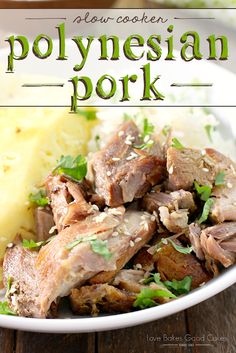 a white bowl filled with meat and potatoes on top of a wooden table next to a fork