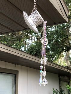 a glass chandelier hanging from the side of a house with trees in the background