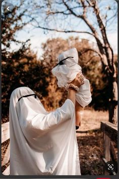 a woman wearing a white veil and covering her face