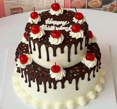 a birthday cake with chocolate icing and cherries