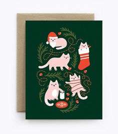 a christmas card with cats and stockings on the front, surrounded by holly wreaths