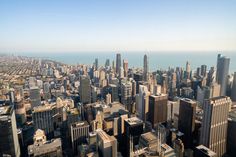 an aerial view of the chicago skyline with skyscrapers in the foreground and lake michigan in the background