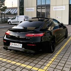 a black sports car parked in front of a building