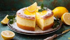 a cake with lemons and powdered sugar on top is sitting on a plate