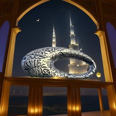 an arch with arabic writing on it and the moon in the sky behind it at night