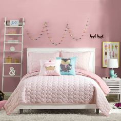 a bedroom with pink walls, white furniture and decorations on the wall above the bed