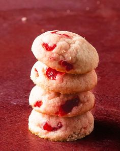 three cookies stacked on top of each other with strawberry jam in the middle one cookie is half eaten