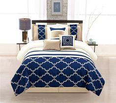 a bed with blue and white comforters in a room