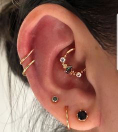 an ear with three different types of piercings on it's sides and one is in the middle