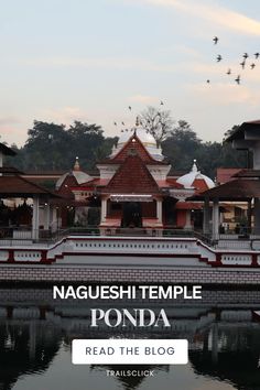 a large building with birds flying over it and the words naqueshi temple ponda read