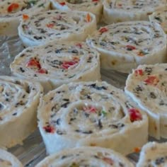 several rolls with various toppings sitting on a glass tray covered in plastic wrappers