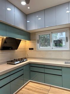 a kitchen with green cabinets and white counter tops