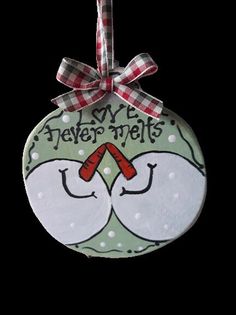 a ceramic ornament hanging from a red and white ribbon