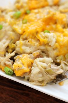 a close up of a plate of food with chicken and rice on it, next to a fork