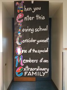 a blackboard with colorful writing on it in a hallway next to a door that says, when you enter this living school consider yourself one of the special