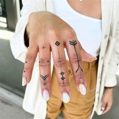 a woman's hand with tattoos on it, and her fingers are shown in front of the camera