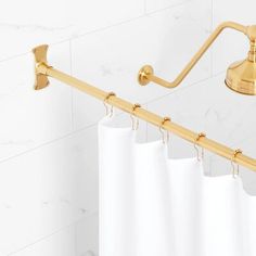 a white shower curtain next to a gold handle on a wall mounted faucet