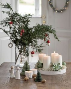 a table topped with candles and christmas decorations