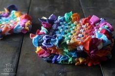 two pieces of colorful fabric sitting on top of a wooden table next to each other