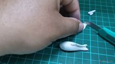 a person is cutting something white with a pair of scissors