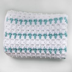 a white and blue crocheted dishcloth on a white surface with green trim