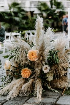 an arrangement of flowers and grasses on the ground at a wedding ceremony in florida, usa