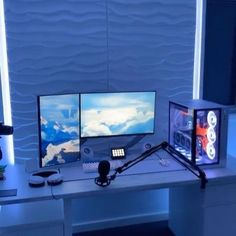 three computer monitors sitting on top of a desk in front of a microphone and headphones