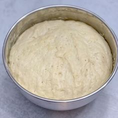 a metal bowl filled with batter sitting on top of a counter